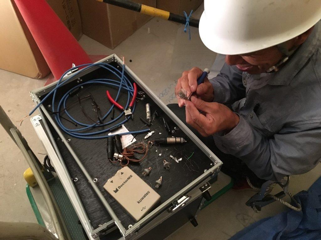 制御するための機材の仕込み作業をしている風景です